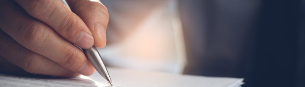 Hand writing with a pen on paper.